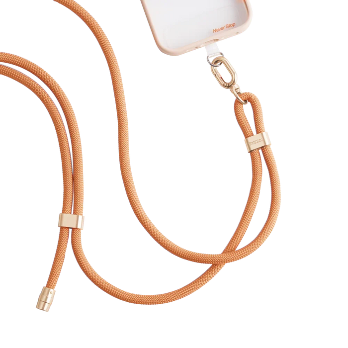 LoopGo Flex crossbody phone lanyard in orange, clipped to a clear phone case