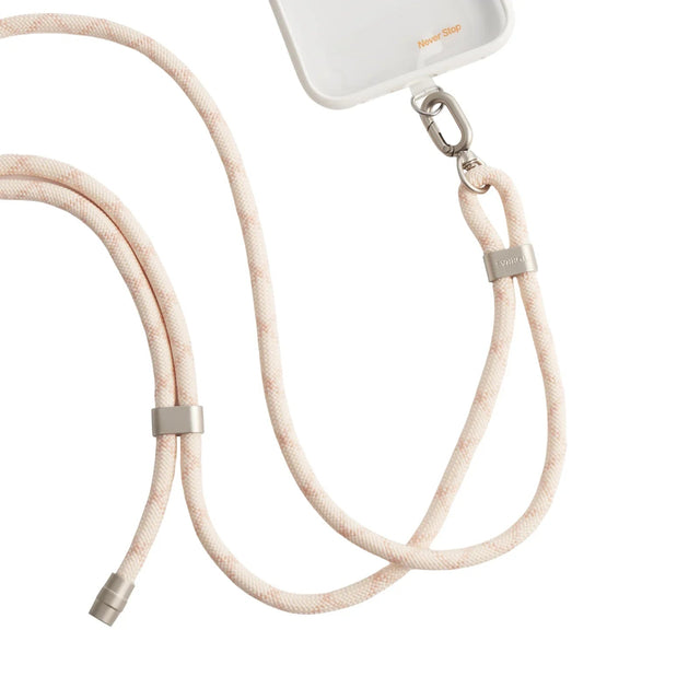 LoopGo Flex crossbody phone lanyard in sand beige, clipped to a clear phone case