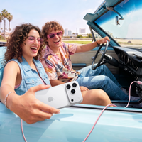 Two friends in a convertible with an iPhone charging on a pink TORRAS NeoCable 60W cable