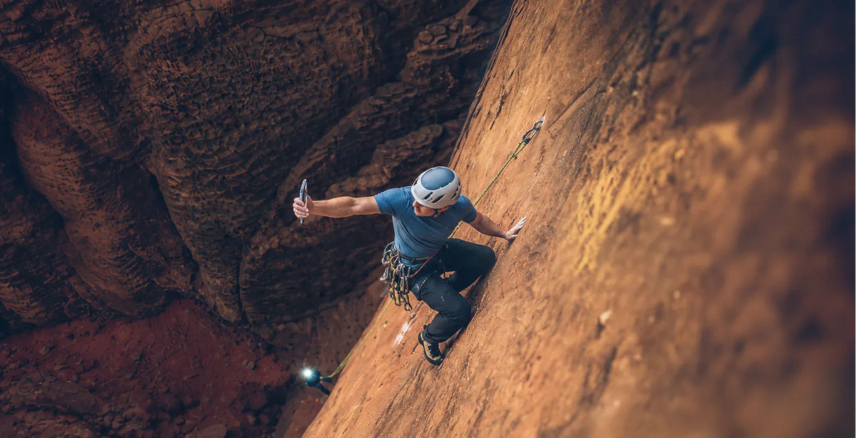 Climber on a sandstone wall taking a selfie with an iPhone