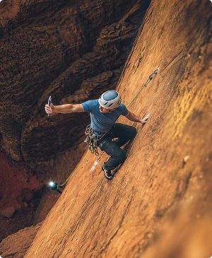 Climber on a sandstone wall taking a selfie with an iPhone