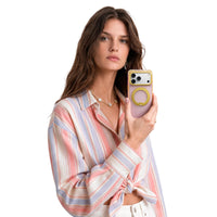 Woman in a pastel striped shirt holding an iPhone 18 Pro Max in the pink Bios Air case with a yellow ring