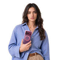 Woman in a blue striped shirt holding an iPhone 18 Pro Max in the pink Bios Air case with a pink ring stand