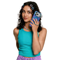 Woman in a teal tank top holding an iPhone 18 Pro Max in the blue-violet Hue case with a teal ring