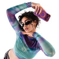 Woman in a tie-dye mesh top holding up an iPhone 18 Pro Max in the purple Hue case with an orange ring