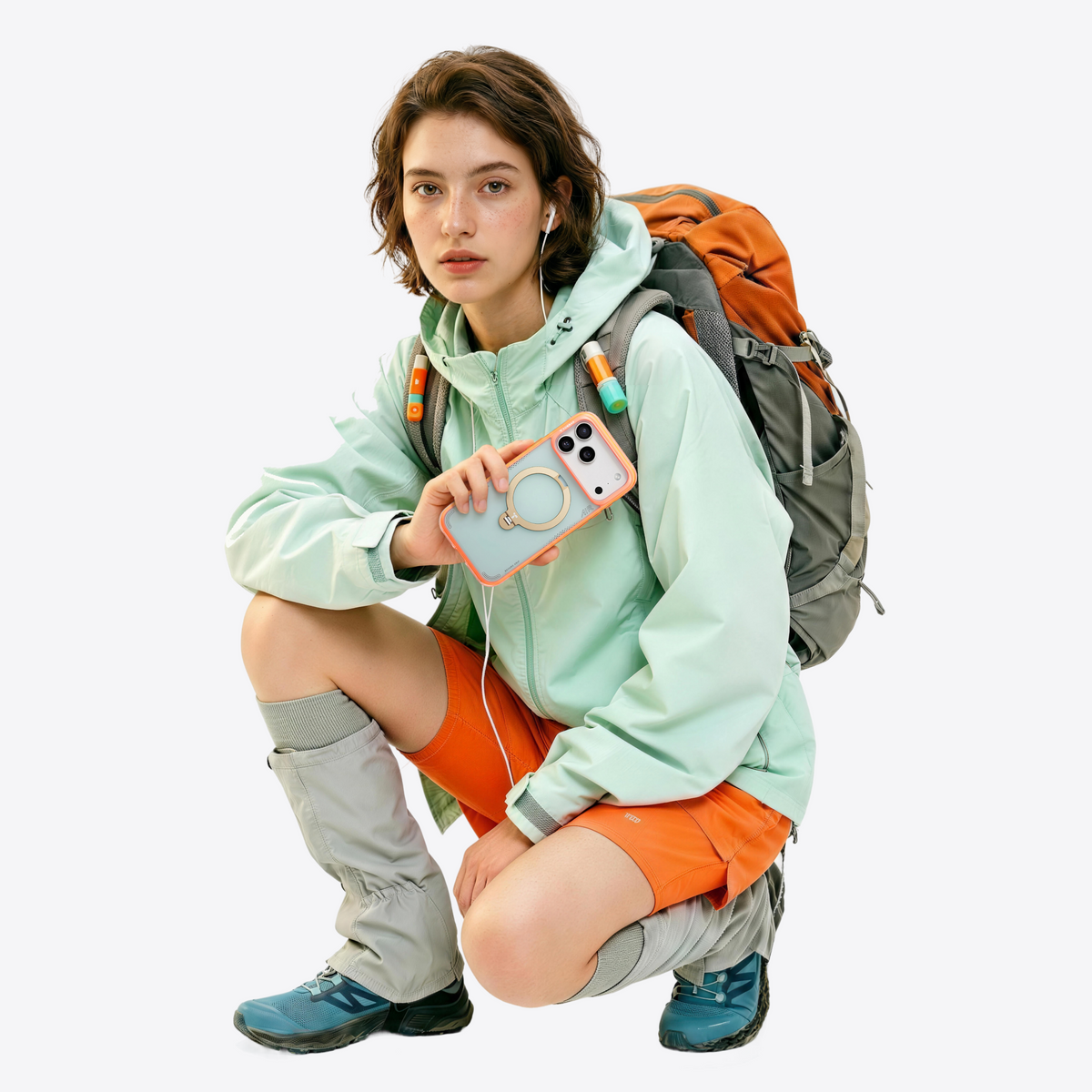 Hiker with a backpack crouching, holding an iPhone 18 Pro Max in the coral Q3 Air Summer case
