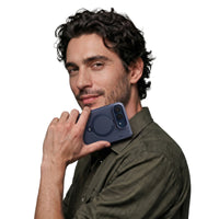 Man holding a folded phone in a Deep Blue Ostand Q3 Spin case, the ring stand visible on the back