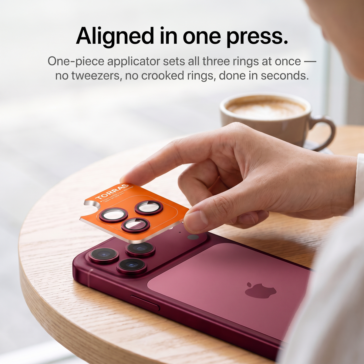 One-piece applicator setting all three lens rings onto a cherry red iPhone 18 Pro in a single press