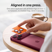 One-piece applicator setting all three lens rings onto a cherry red iPhone 18 Pro in a single press