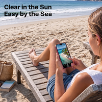 Woman on a beach lounger reading her phone screen in bright sun, captioned clear in the sun