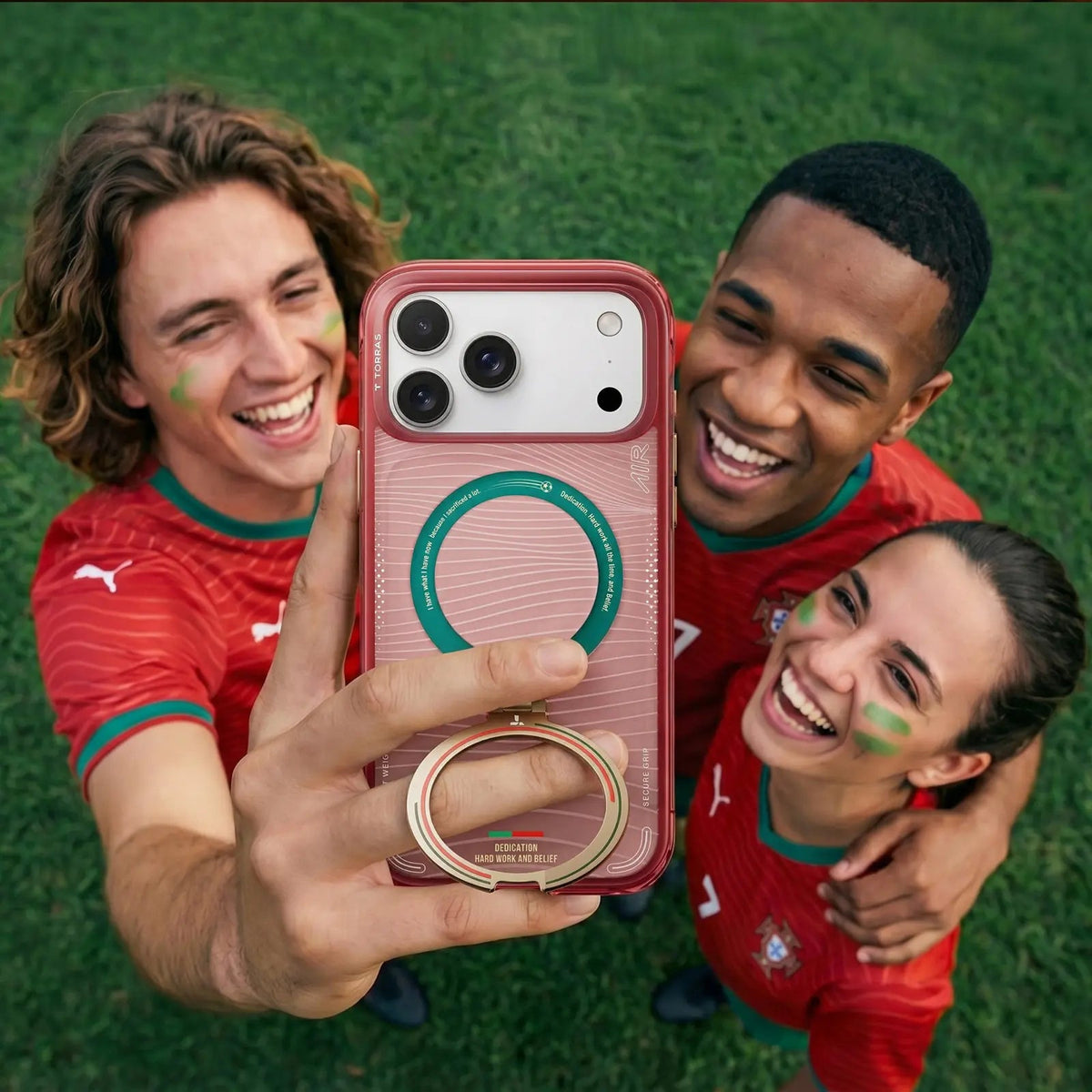 Three Portugal fans on the grass taking a selfie with an iPhone in the pink FPF case